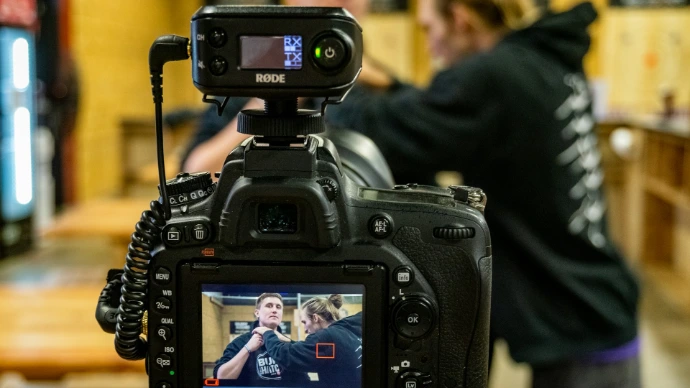 black DSLR camera beside two person